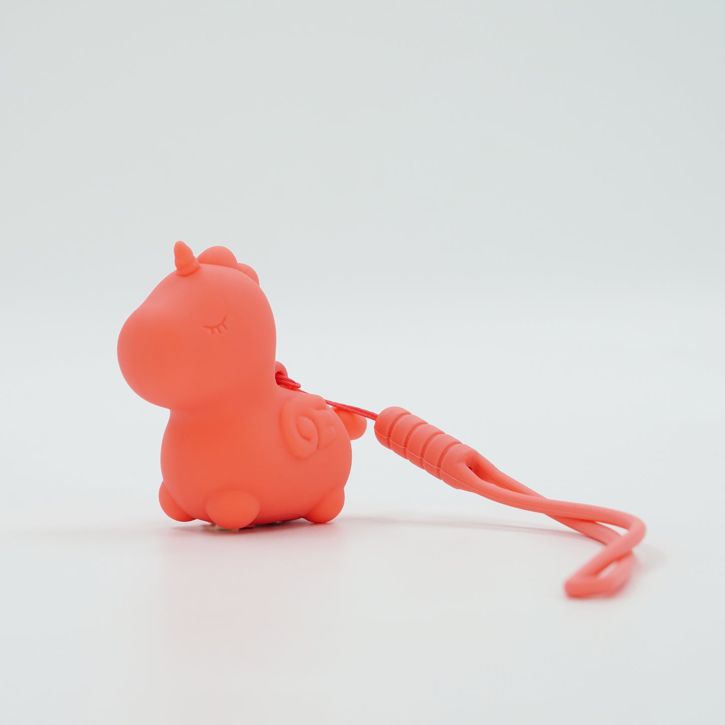 Peachy Pony with the keychain attached on a white background