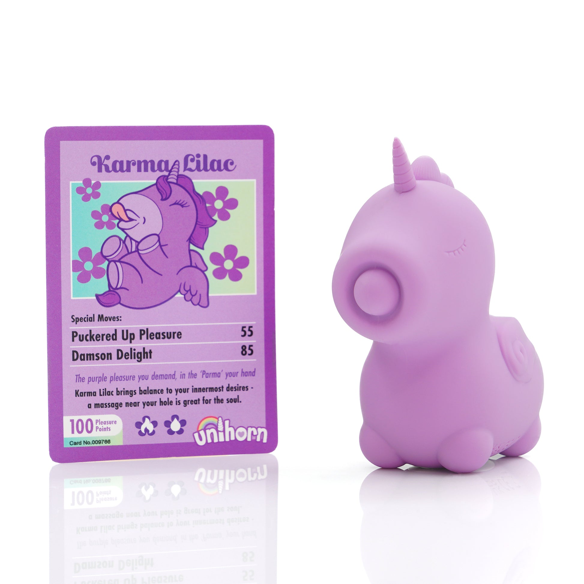 Purple Karma Lilac Unihorn stood next to the Karma Lilac collectors cards on a white background