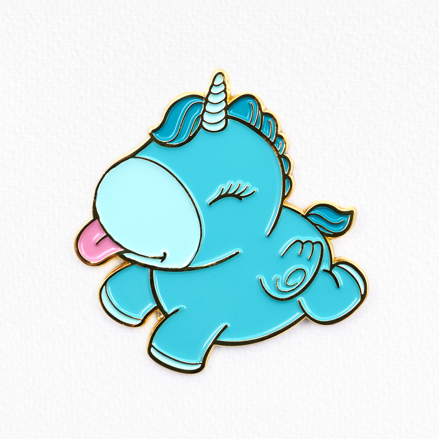 Animated Mount N' Peak blue pin badge with it's tongue out, on a textured white background