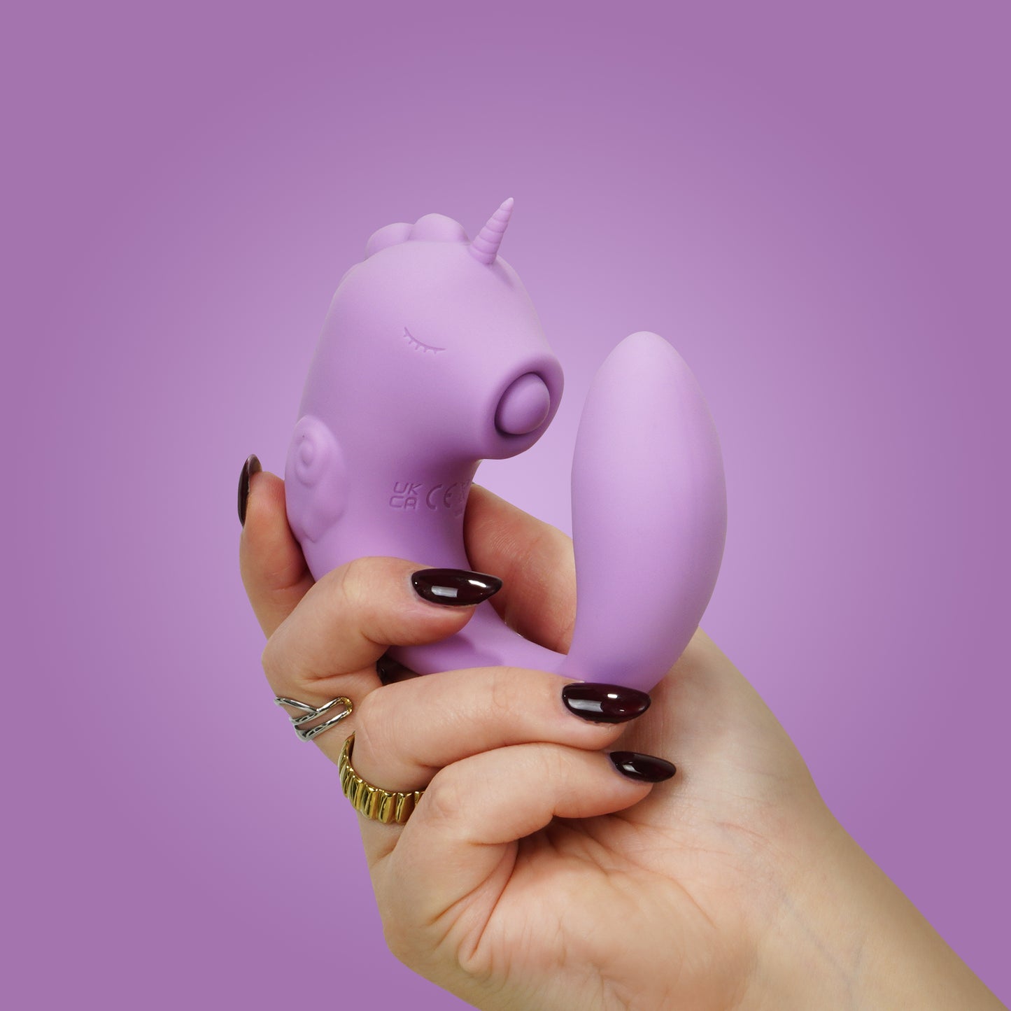 Marina Lilac Unihorn C-Horse in natural c-shaped position in hand on a purple background