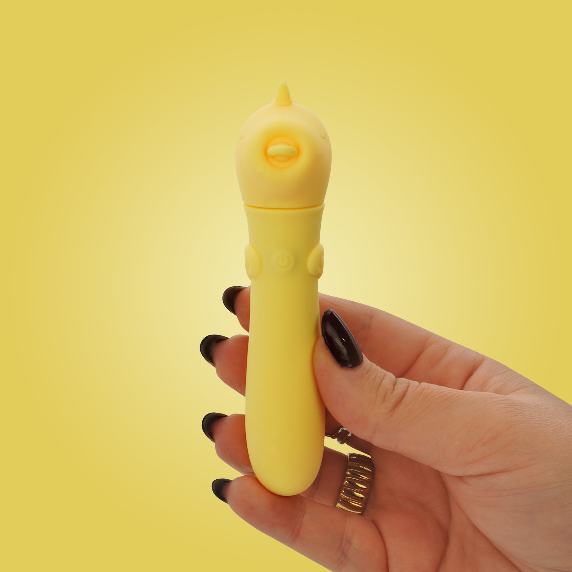 Hand with black nails holding Bean Blossom USB bullet on a bright yellow background
