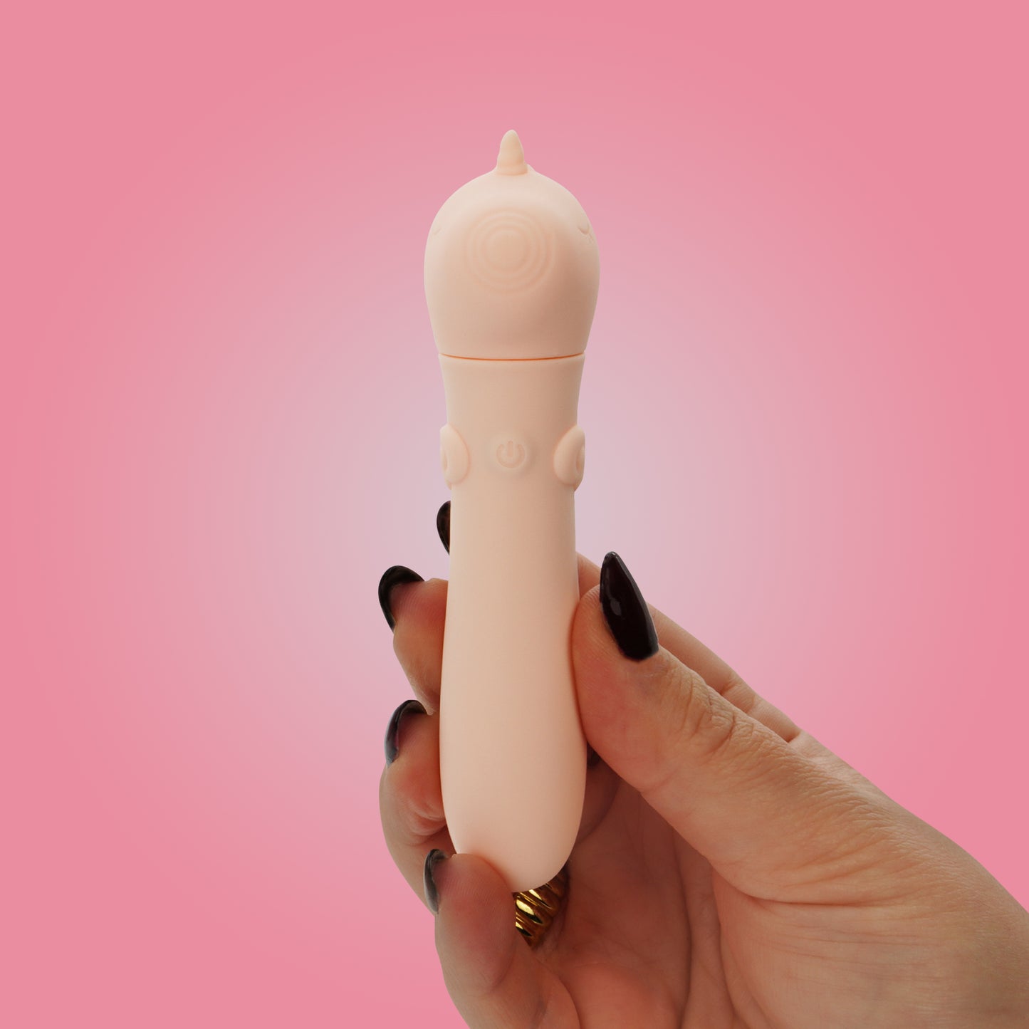 Hand with black nails, holding Heart Throb bullet vibrator on a bright pink background