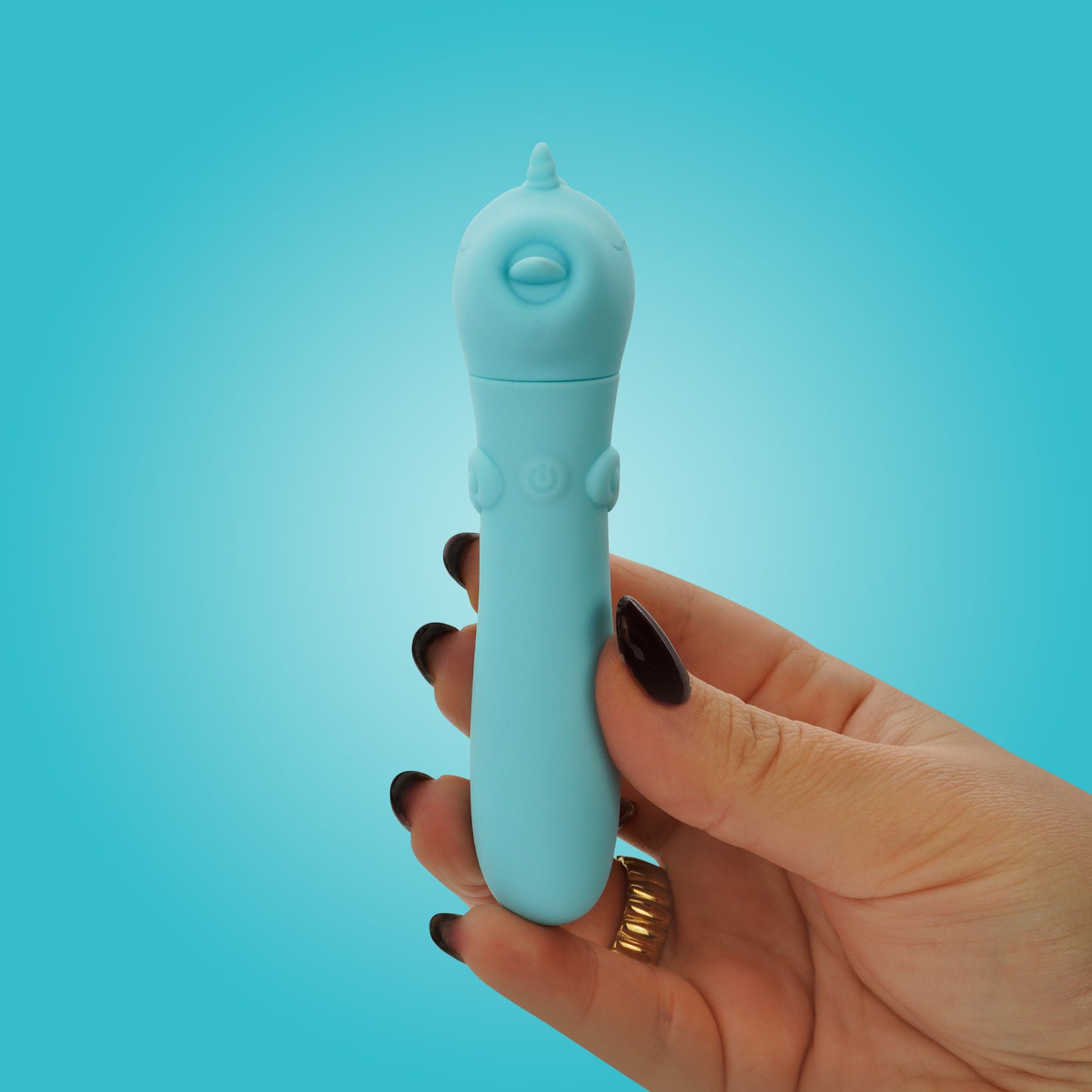 Hand with black nails holding the Mount N' Peak bullet vibrator on a bright blue background