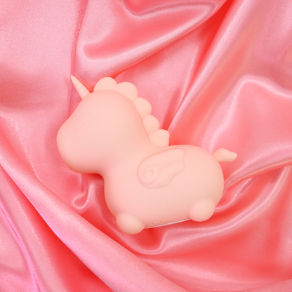 Heart Throb Unihorn vibrator, laid down facing the left on a pink satin sheet