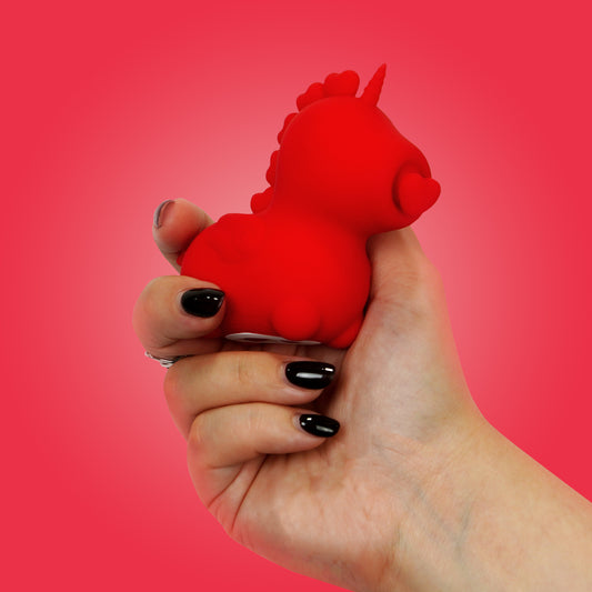 Cupid's Beau OG Unihorn in a hand on a red background