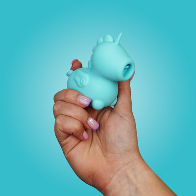 Hand holding blue Bean Blossom, facing slightly right on a bright blue background