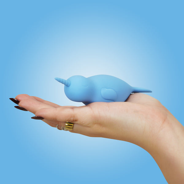 An angled view of Neigh Mo Unihorn vibrator in a hand with a blue background